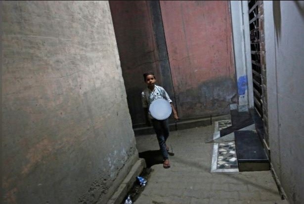 A kid beating drum to wake up the villagers as loudspeakers are banned in the mosques in Nayaban Nayaban muslims