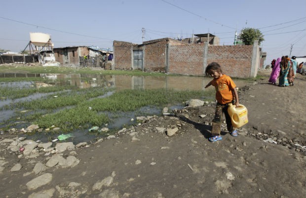 A girl carries water in a slum area next to the Union Carbide Corp pesticide plant in Bhopal. (File Photo) Bhopal Gas Tragedy