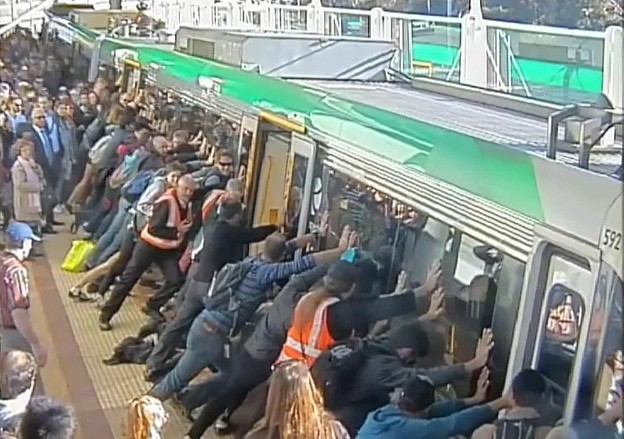 Passengers push train to save man trapped under it Passengers push train to save man trapped under it
