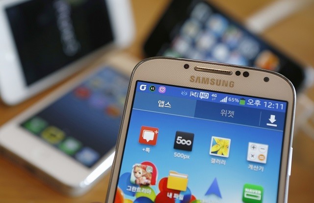 A Samsung Electronics' Galaxy S4 (front) and Apple's iPhone 5 smartphones are seen in this picture illustration taken in Seoul May 13, 2013. Samsung S4