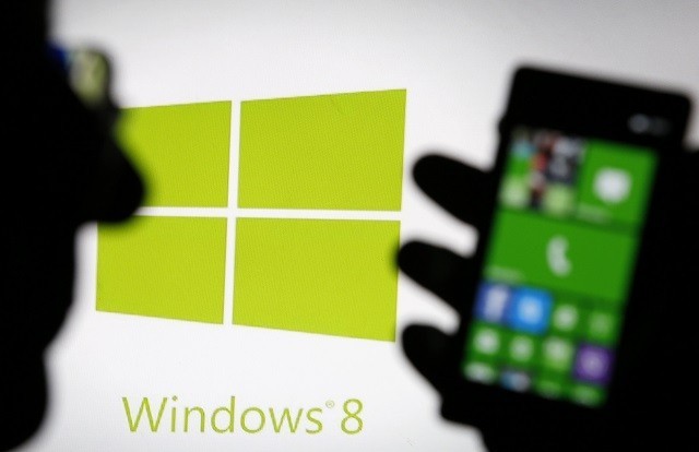 A man is silhouetted against a video screen as he poses with a Lumia 820 smartphone in this photo illustration taken in the central Bosnian town of Zenica Microsoft Lumia phone