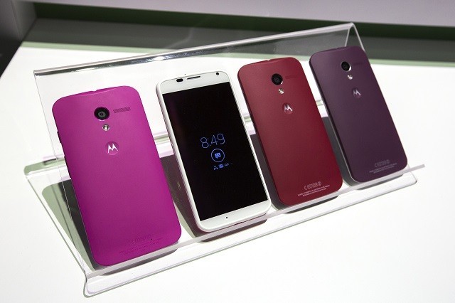 Different coloured Motorola Moto X phones rest on a table at a launch event in New York Motorola Moto X