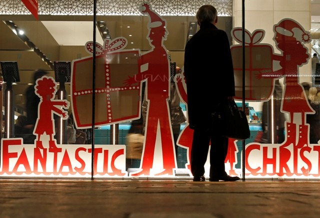 A man looks at a shop window with a decoration of a Christmas sale at a department store Christmas sale scam