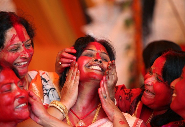 Hindu women apply 'Sindur', or vermillion powder, on the face of a woman during the Durga Puja festival in Chandigarh. The festival is the biggest religious event for Bengali Hindus. Hindus believe that the goddess Durga symbolises power and the triumph of good over evil. Durga Puja festival