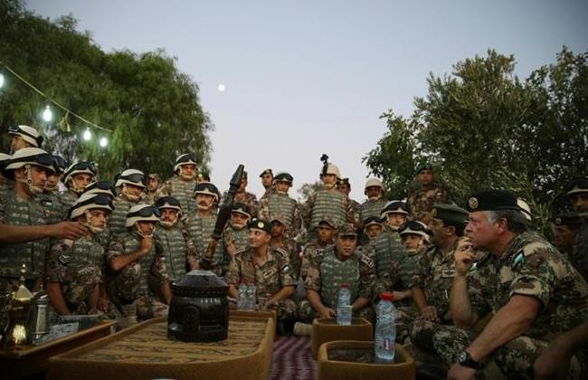 Jordan's King Abdullah (R) listens to members of the Jordanian army during his visit to a northern borders guards
