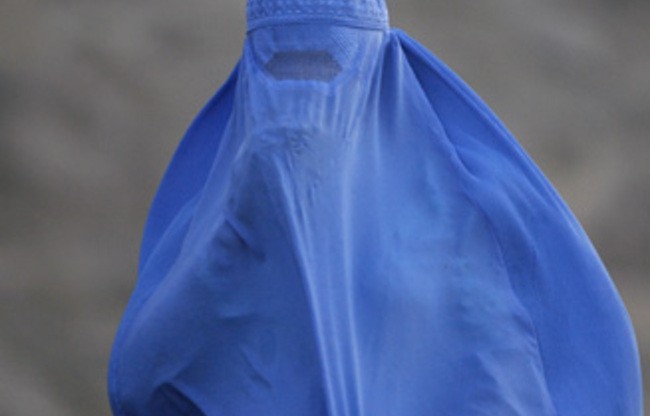 A woman wearing the traditional burqa. A woman wearing the traditional burqa.