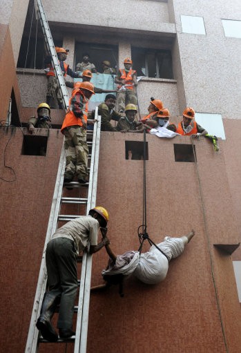 Rescue workers use ropes to evacuate people. AMRI/Kolkata Fire