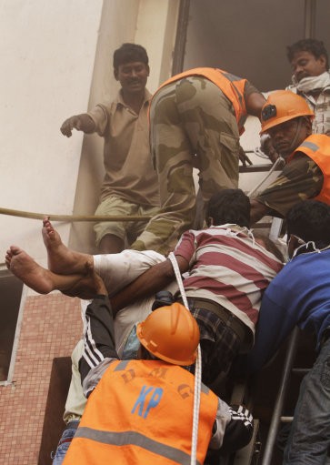 Rescue workers use ropes to evacuate people. AMRI/Kolkata Fire