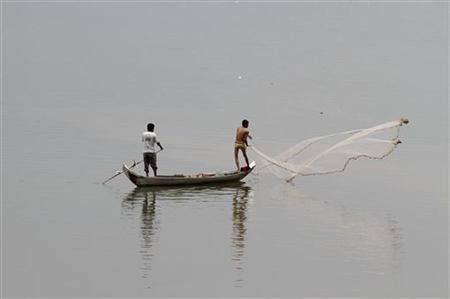 Cambodian fishermen cast their net into the Mekong River outside Phnom Penh April 19, 2011.