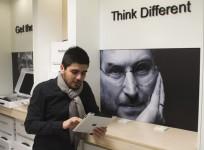 man-checks-apple-ipad-as-he-stands-next-to-portrait-of-late-apple-co-founder-jobs-at-shop-in-payetakht-computer-centre-in-northern-tehran