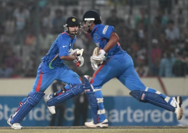 India's Dhoni and Kohli run between the wickets against Pakistan during their Asia Cup One Day International cricket match in Dhaka