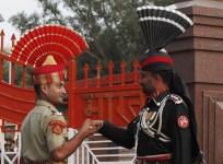 A Pakistani Ranger and an Indian Border Security Force officer shake hands during the daily parade at the Pakistan-India joint check-post at Wagah border