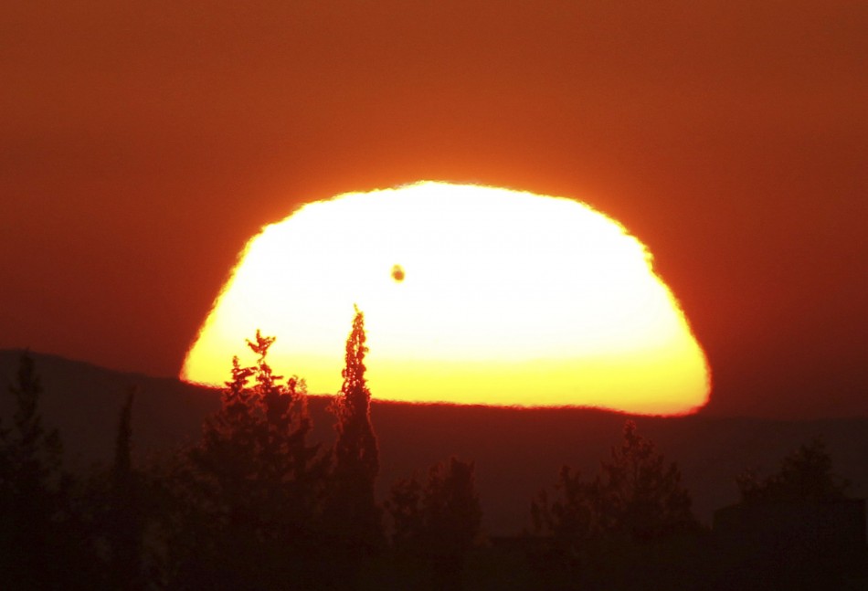 The planet Venus is seen as a black dot as it makes its transit across the sun over Amman Venus Transition seen in Amman
