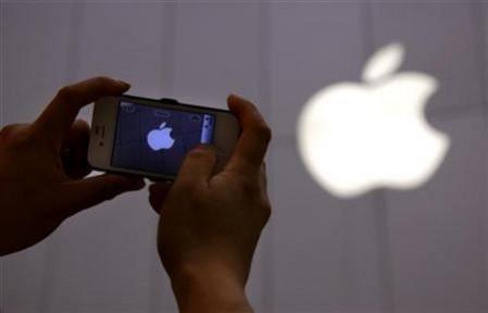 A man shows a photograph he took on his iPhone of an Apple store in Beijing June 6, 2012. Apple