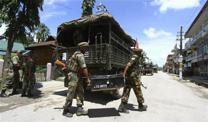 Indian army soldiers carry a trunk containing ammunition next to their truck during a curfew at Kokrajhar town in Assam Assam Violence