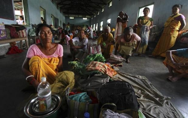 Villagers affected by the ethnic riots sit with their belongings inside a relief camp near Goshaigaon town in Assam Assam Violence