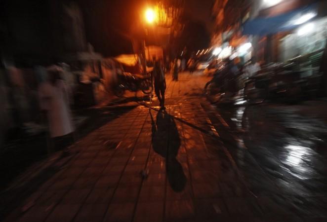 A man walks on an illuminated street after electricity was restored in New Delhi (Reuters) Blackouts in India