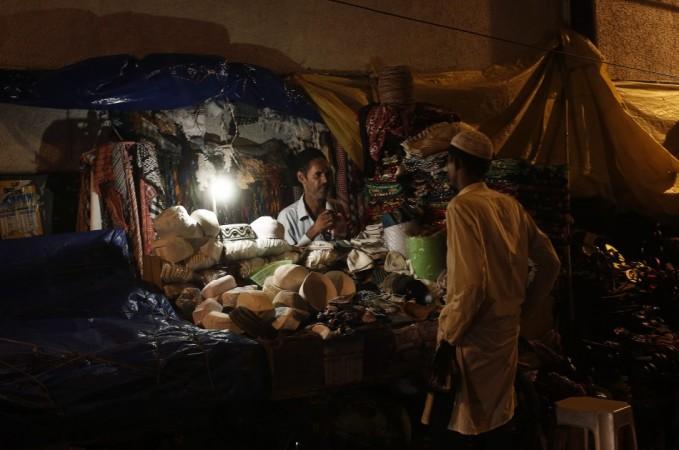 A shopkeeper interacts with a customer at his illuminated shop after electricity was restored in New Delhi (Reuters) Blackouts in India