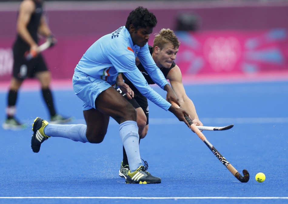 India's Tirkey is challenged by New Zealand's Edwards during their men's Group B hockey match at the London 2012 Olympic Games at the Riverbank Arena on the Olympic Park India