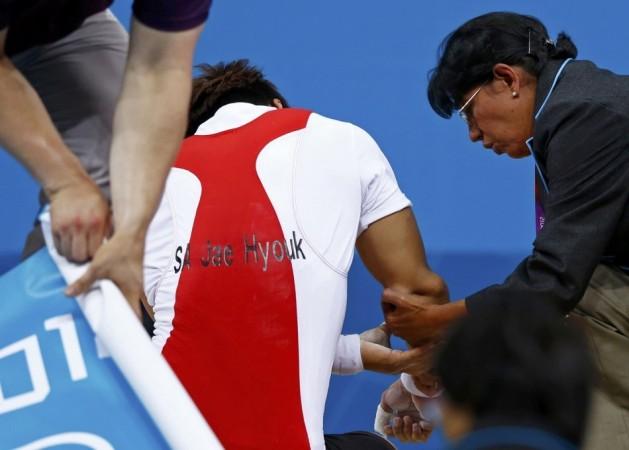 South Korea's Jaehyouk Sa is assisted after get injured on the men's 77Kg Group A weightlifting competition at the ExCel venue at the London 2012 Olympic Games. Source: Reuters South Korean Weightlifter Champion Sa Jae-hyouk Elbow Dislocated