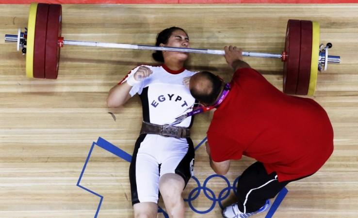 Egypt's Khalil K Abir Abdelrahman is assisted after failed attempt on the women's 75Kg group A weightlifting competition at the ExCel venue at the London 2012 Olympic Games August 3, 2012. REUTERS/ Egypt's Khalil K Abir Abdelrahman