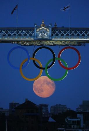 The full moon rises through the Olympic Rings hanging beneath Tower Bridge during the London 2012 Olympic Games August 3, 2012. REUTERS/Luke MacGregor Sixth Olympic ring