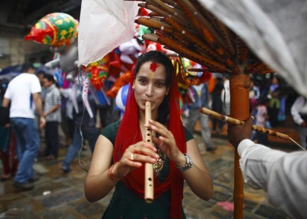 A woman blows a flute to check it before buying, near the Krishna Temple in Lalitpur (Reuters) Janmashtami