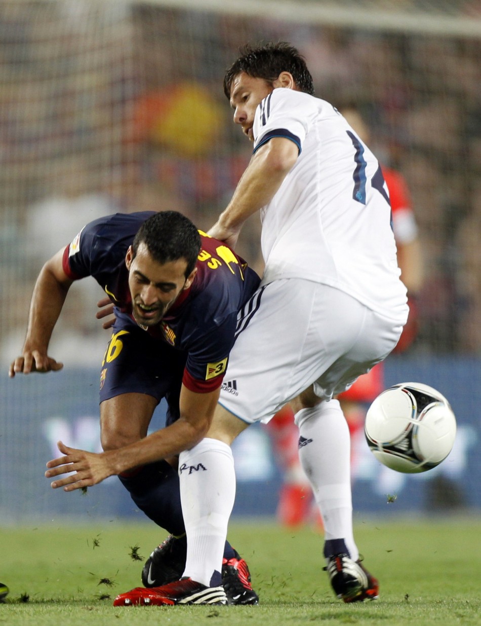 Real Madrid's Alonso and Barcelona's Busquets challenge for the ball during their Spanish Super Cup first leg soccer match in Barcelona Real Madrid, Barcelona