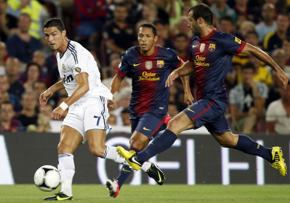 Real Madrid's Ronaldo passes the ball as Barcelona's Mascherano and Adriano challenge during their Spanish Super Cup first leg soccer match at Nou Camp stadium in Barcelona Real Madrid, Barcelona