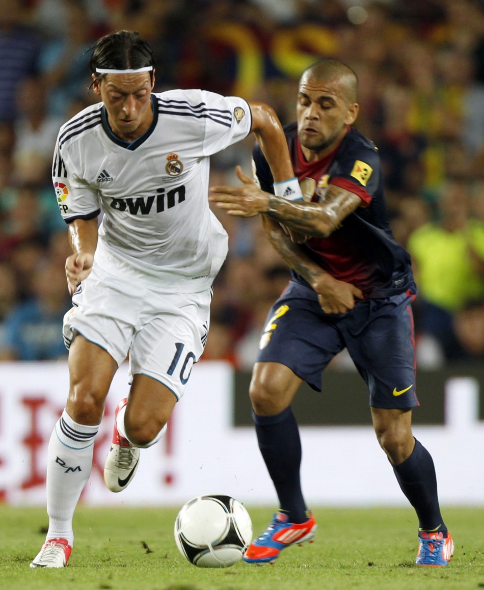 Real Madrid's Ozil and Barcelona's Alves fight for the ball during their Spanish Super Cup first leg soccer match in Barcelona Real Madrid, Barcelona