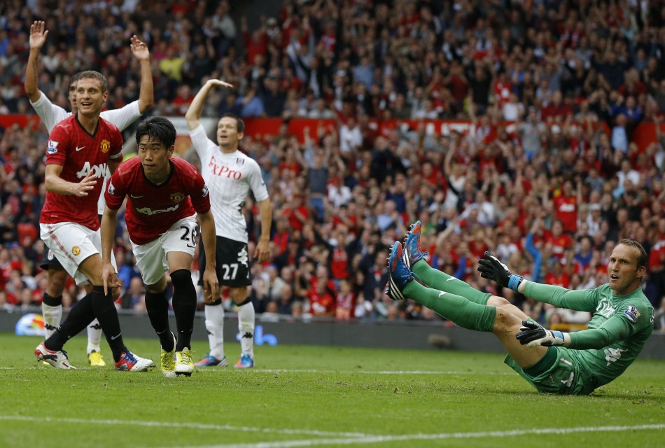 Fulham's goalkeeper Mark Schwarzer reacts as Manchester United's Shinji Kagawa celebrates his goal during their English Premier League soccer match at Old Trafford in Manchester Fulham, Mark Schwarzer