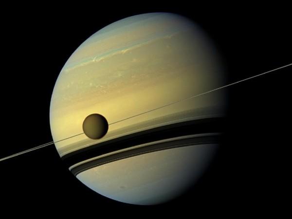 A giant of a moon appears before a giant of a planet undergoing seasonal changes in this natural color view of Titan and Saturn from NASA's Cassini spacecraft. Source: NASA/JPL-Caltech/SSI Saturn And Titan