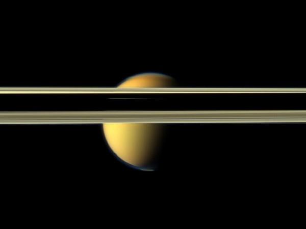 Saturn's rings obscure part of Titan's colorful visage in this image from NASA's Cassini spacecraft. Source: NASA/JPL-Caltech/SSI Saturn And Titan