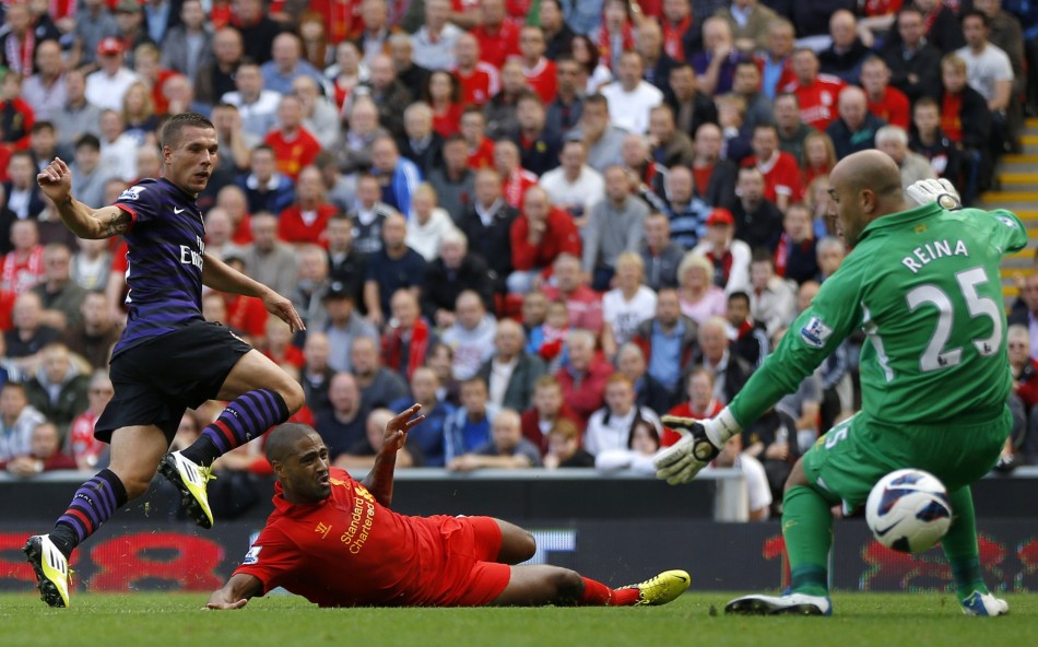 Arsenal's Podolski shoots past Liverpool's Reina and Johnson to score during their English Premier League soccer match in Liverpool Arsenal, Liverpool