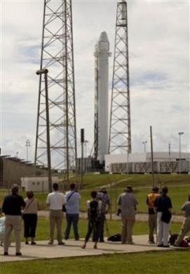 People watch as Space Exploration Technologies' Falcon 9 rocket is prepared for a launch attempt from Space Launch Complex 40 at the Cape Canaveral Air Force Station in Cape Canaveral, Florida October 7, 2012. Space x