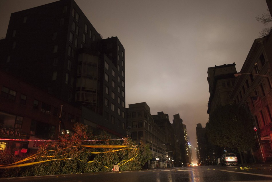 A fallen tree lays along a darkened Sixth Avenue in Chelsea during a blackout believed to be caused by rising river waters as Hurricane Sandy made its approach in New York Hurricane Sandy