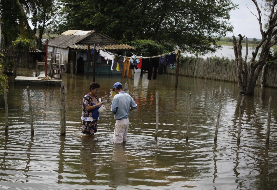 A woman gets groceries delivered by a man in her yard flooded after Hurricane Sandy passed through the village of Hoyo Colorado Hurricane Sandy