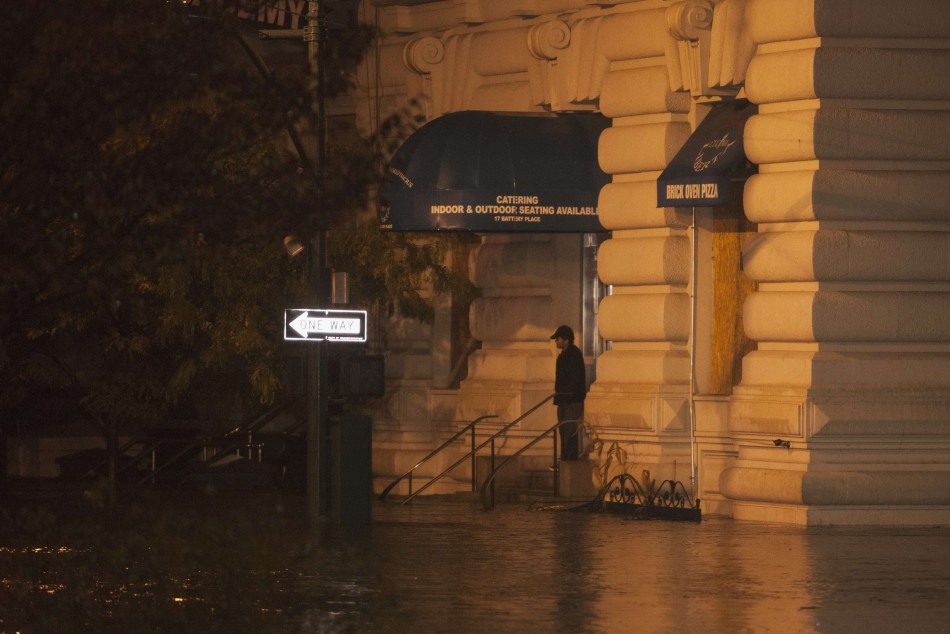 A man stands in front of a flooded building in Manhattan as Hurricane Sandy made its approach in New York Hurricane Sandy