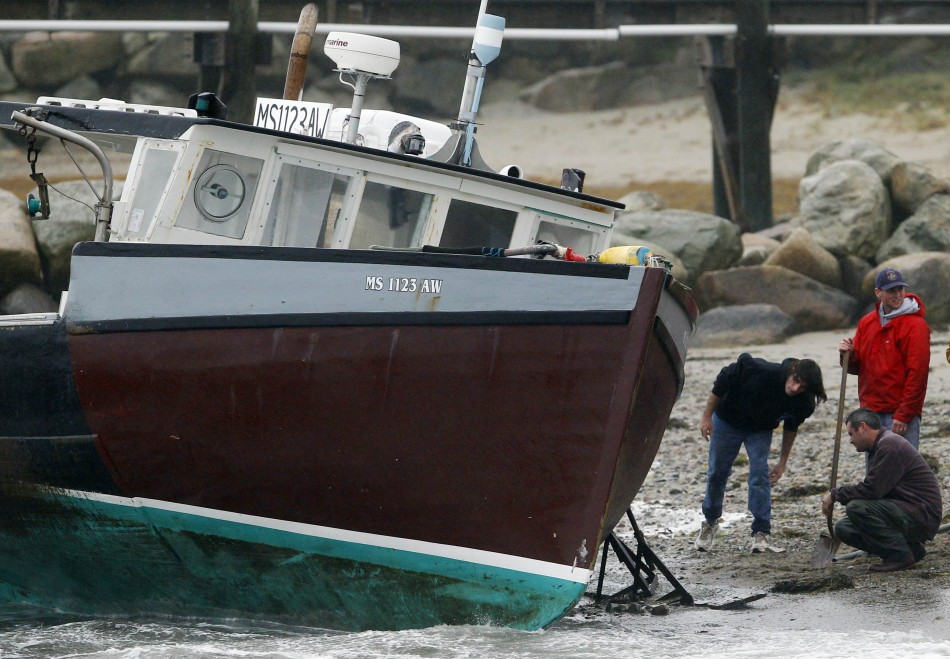 Men try to save a boat which became unmoored and washed up on shore due to high winds from Hurricane Sandy in Scituate Hurricane Sandy