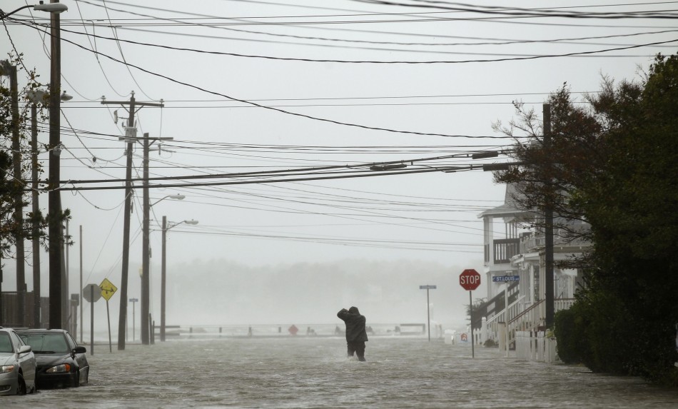 Powerlines hang overhead as a man wades through a street flooded during Hurricane Sandy in Ocean City Hurricane Sandy