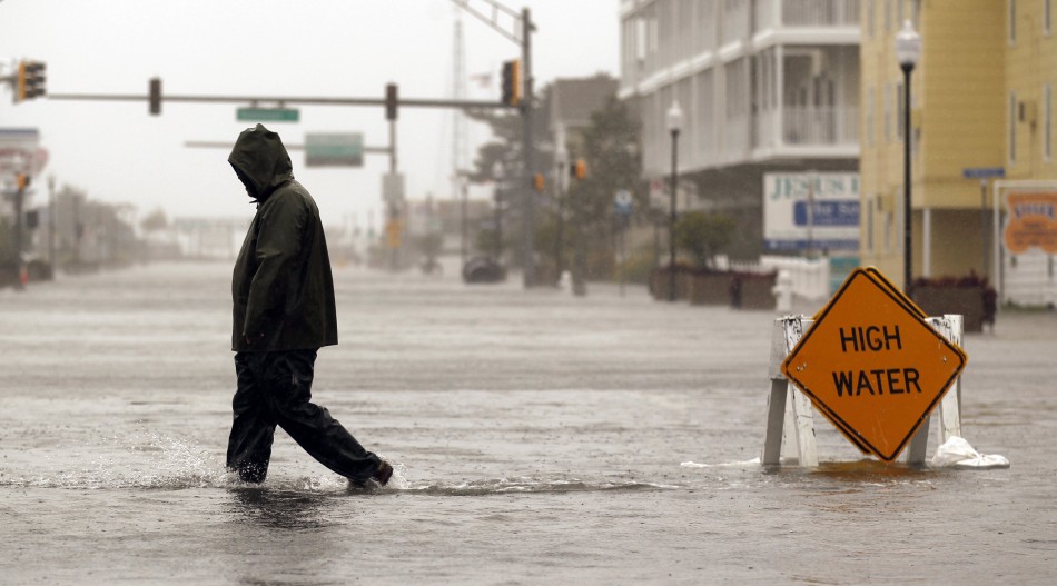 A man crosses a street flooded during Hurricane Sandy in Ocean City Hurricane Sandy