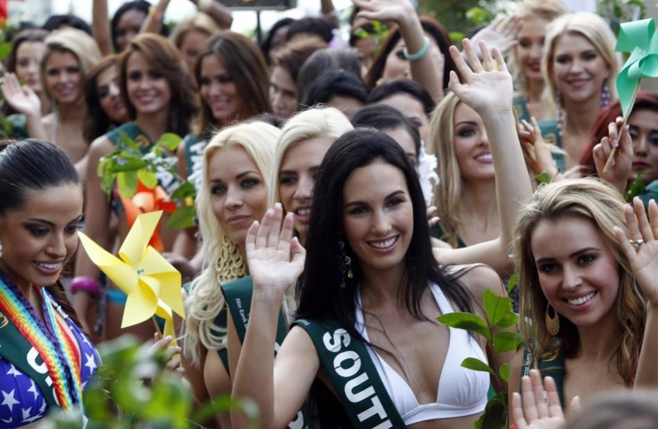 Candidates of the Miss Earth beauty contest, holding tree seedlings and pinwheels to promote sustainable energy, wave to photographers during a media presentation at a hotel in Taguig City Miss Earth 2012