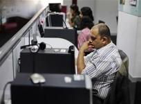 office-workers-sit-in-front-of-their-workstations-on-the-floor-of-an-outsourcing-centre-in-bangalore-february-29-2012