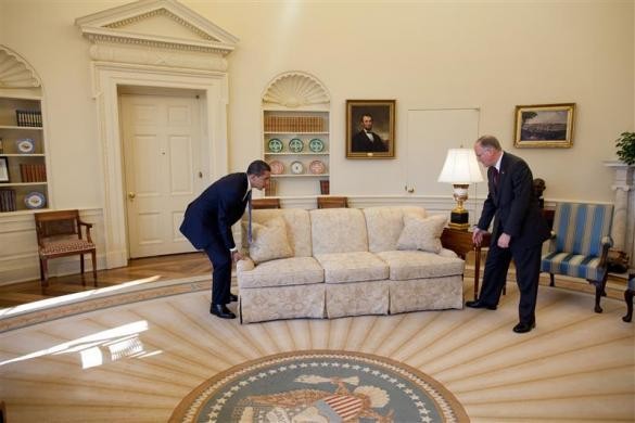 President Barack Obama is helped by then Vermont Governor Jim Douglas to move a couch in the Oval Office, February 2, 2009. Barack Obama