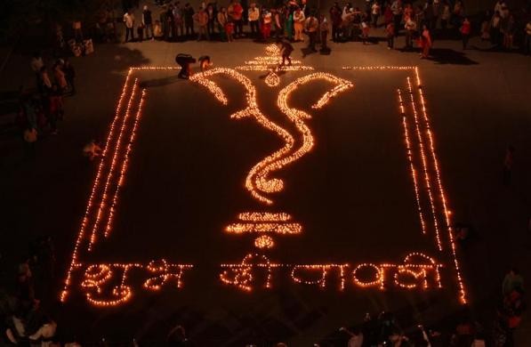 People light earthen lamps in a formation to form the shape of Hindu god Ganesh, the deity of prosperity, on the eve of Diwali in Chandigarh. The letters in Hindi language reads, 'Happy Diwali.' Diwali Celebrations