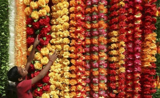 A vendor arranges artificial garlands for sale at his stall ahead of Diwali in Jammu. Diwali Celebrations