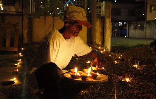 A man places lighted diyas in his yard during Diwali celebrations in Felicity, central Trinidad. Diwali Celebrations