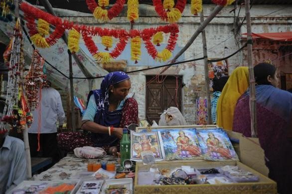 Heera Maasi, 60, arranges Diwali festival souvenirs as she awaits customers along a roadside stall in Karachi Diwali Celebrations