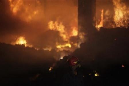 A firefighter tries to control a fire at a garment factory in Savar, outskirts of Dhaka November 24, 2012. REUTERS/Andrew Biraj Fire in Bangladesh clothing factory