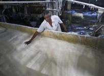 a-worker-spreads-sugar-inside-a-sugar-factory-at-sanyan-village-in-gujarat-april-23-2012